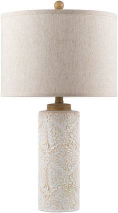 a white table lamp with a beige shade on the base and a light brown drum