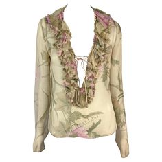 Presenting a fabulous tan sheer Gucci ruffle top, designed by Tom Ford. From the Spring/Summer 2003 collection, this chic top is covered in a bold floral print. Entirely sheer, the top features a plunging neckline framed by a ruffle accent that wraps around the neck. The top is made complete with long sleeves and a tie closure at the bust. Approximate measurements: Size - 44IT Shoulder to hem: 23" Bust: 36" Waist: 34" Shoulder to cuff: 27" Underarm to cuff: 22" Materials tag removed. Chic Luxury Gucci Tops, Gucci Long Sleeve Party Tops, Spring Fitted Gucci Shirt, Gucci Sleeveless Fitted Top, Gucci Fitted Luxury Blouse, Elegant Silk Gucci Tops, Fitted Gucci Top For Night Out, Fitted Gucci Top With Button Closure, Gucci Blouse