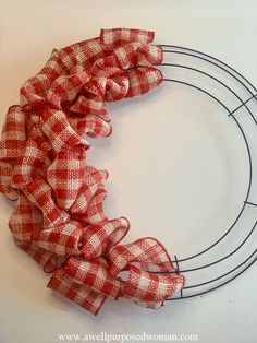 a red and white checkered ribbon on a wire wreath