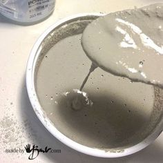 a white bowl filled with lots of dirt next to a bottle of toothpaste