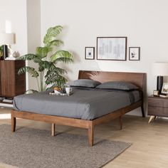 a bed sitting on top of a wooden floor next to a dresser