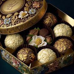 there are many chocolates in the box and one is white with gold decorations on it