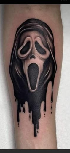 a black and white tattoo with a scream mask on it