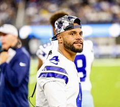 a close up of a football player on the field with other players in the background