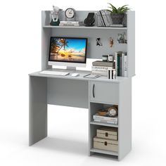 a computer desk with a monitor and keyboard on top of it, next to some books