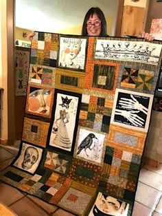 a woman holding up a quilt made with pictures