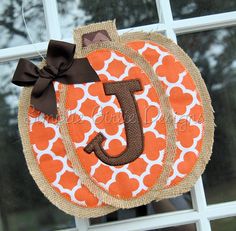 an orange and white door hanger with the letter j on it