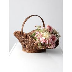 a basket filled with flowers sitting on top of a white counter next to a wall