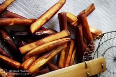 some french fries are in a basket on a towel and next to a wire rack