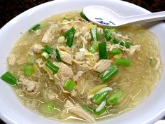 a white bowl filled with soup and green onions