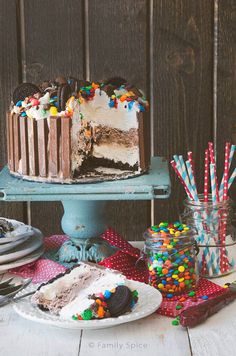 there is a cake on the table with many different toppings and candy sticks in front of it