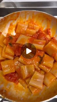 a pan filled with pasta and sauce on top of a stove