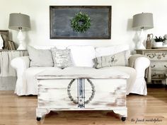 a white couch sitting on top of a hard wood floor next to a wooden table