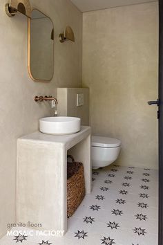 a bathroom with a sink, toilet and mirror in it's corner area next to a door