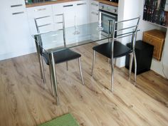 a glass table and chairs in a kitchen