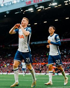 two soccer players are celebrating on the field