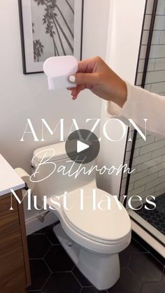 a person is holding an item in front of a bathroom toilet with the caption amazon bathroom must haves