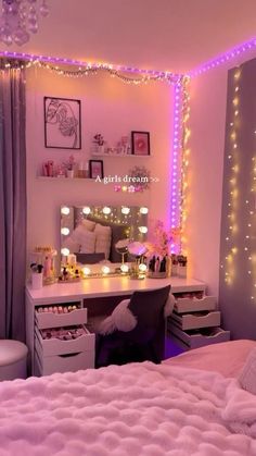 a bedroom decorated in pink and purple with lights on the wall, vanity desk and bed