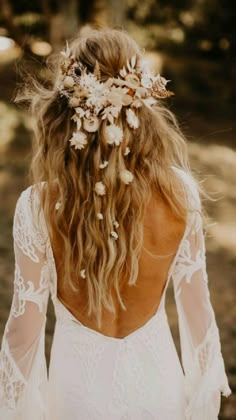 the back of a woman's head wearing a white dress with flowers in her hair