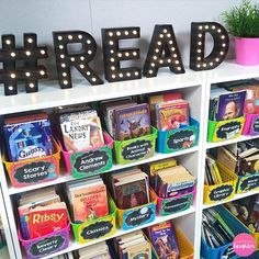 a book shelf filled with lots of children's books next to a sign that says read