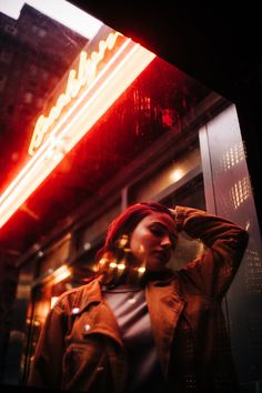 a man standing in front of a neon sign