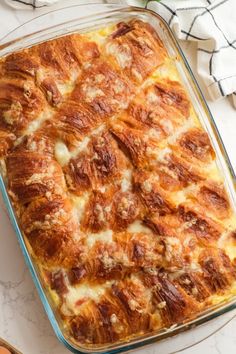 a casserole dish with cheese and meat in it on a white counter top