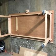 an unfinished piece of wood sitting on top of a wooden shelf next to a wall