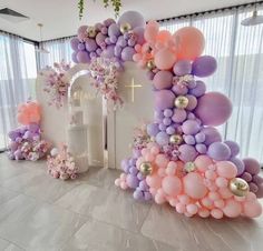 an arch made out of balloons and flowers