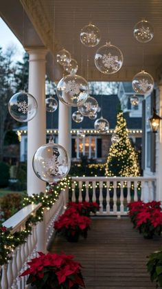 christmas decorations hanging from the front porch of a house with lights and poinsettias