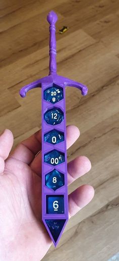 a hand holding a purple toy with numbers on it