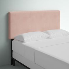 a pink headboard with two white pillows on it