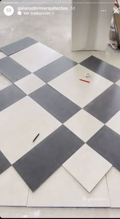 a checkered tile floor is being worked on with scissors and glue in preparation for painting