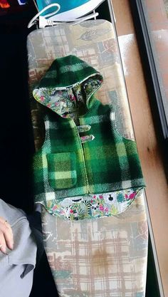 a snowboard with a green and white jacket on top of it next to a window