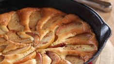 an apple cobble cake in a cast iron skillet on a wooden table with red napkin