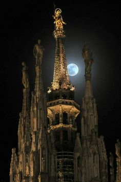 the eiffel tower is lit up at night in front of the full moon