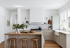 a kitchen with two stools and an island in front of the stove top oven