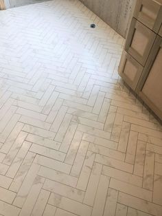 a bathroom with white marble flooring and wooden cabinetry next to it is under construction