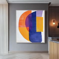 an abstract painting hangs on the wall next to a marble countertop in a modern kitchen