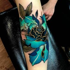 a blue flower tattoo on the arm