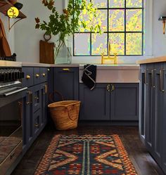 a kitchen with blue cabinets and an area rug