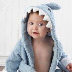 a baby wearing a blue towel with a shark on it's head