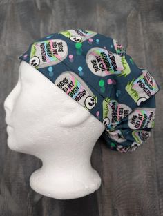 a white mannequin head wearing a blue scrub hat with skulls and polka dots