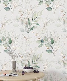 a table with some fruit on it next to a wallpapered background that has leaves and berries