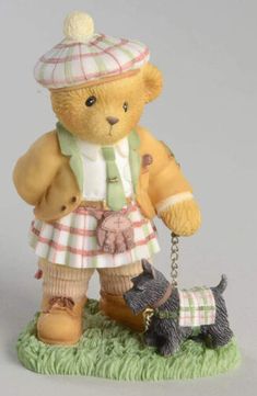 a figurine of a teddy bear holding a dog on a leash and wearing a hat