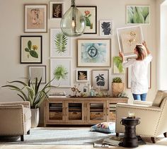 a woman standing in front of a living room filled with pictures