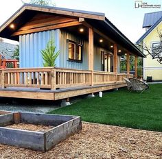 a small house with a porch and deck in the grass next to a yard area