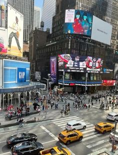 a busy city street filled with lots of traffic and tall buildings covered in billboards