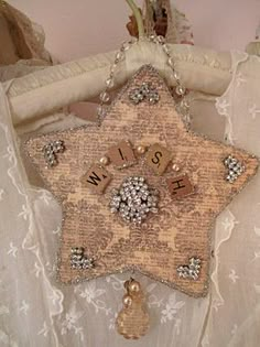 a star shaped brooch hanging on a white dress with lace and beadwork