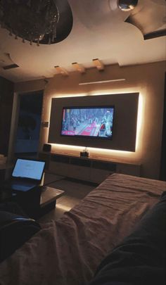 a living room with a flat screen tv on the wall and lights in the ceiling