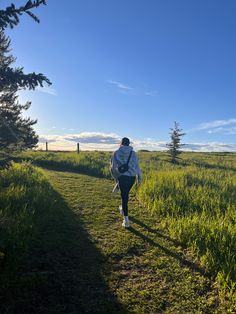 a person walking down a path in the grass